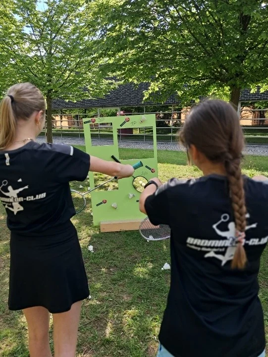 Foto von Kindern, die an einer Zielwand Badminton spielen