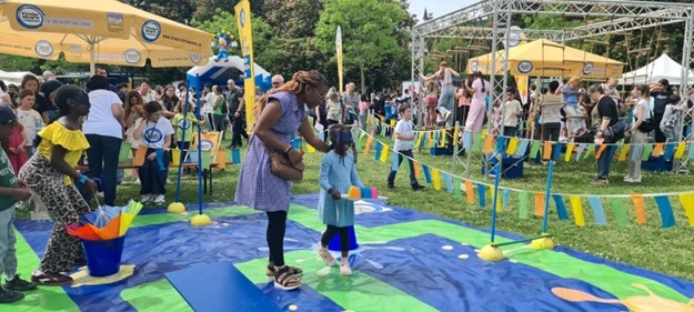 Foto von früherem Familientag. Darauf sind viele Menschen und spielende Kinder zu sehen am Stand von »Kinder stark machen«