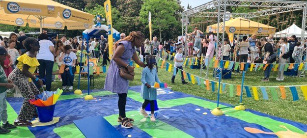 Foto von früherem Familientag. Darauf sind viele Menschen und spielende Kinder zu sehen am Stand von »Kinder stark machen«