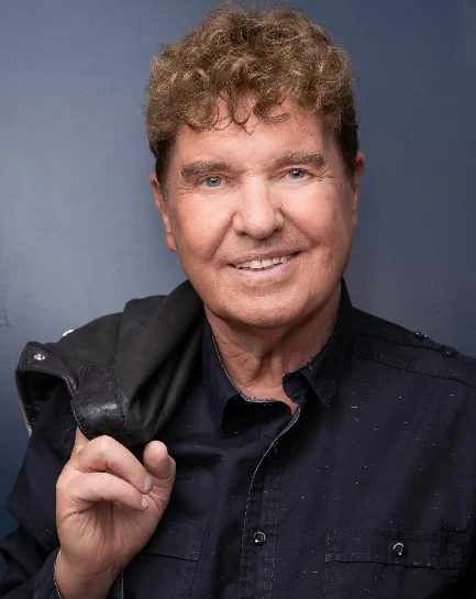 Porträt des Musikers Frank Schöbel. Er lächelt in die Kamera.